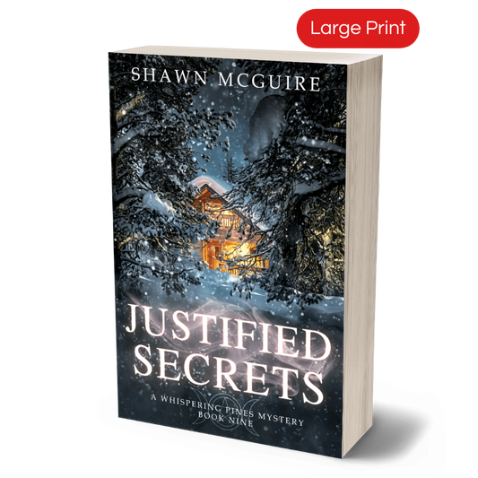 Large print paperback cover of Shawn McGuire's cozy murder mystery featuring a cabin in the woods during a snowstorm.
