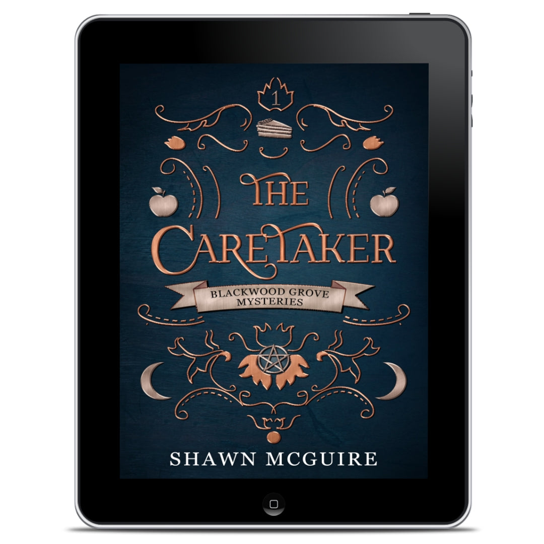 E-book cover on e-reader of Shawn McGuire’s witch cozy paranormal midlife mystery series blue background with scrollwork and apples, moons, and slice of pie icons.