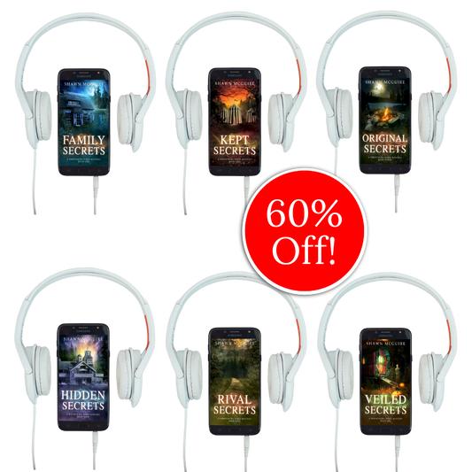 Audiobook covers on cellphones of Shawn McGuire’s 13-book cozy murder mystery series collection books 1-6.